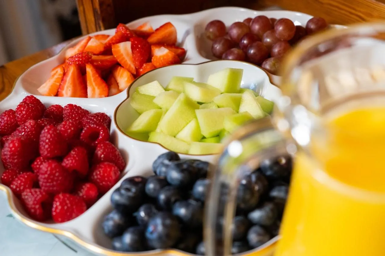 a tray of fruit and vegetables on a table with a drink at Barbican House in York